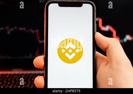 BNB app di criptovaluta analisi del mercato azionario sullo schermo del telefono cellulare in mani di uomo e downtrend grafici di negoziazione dati sullo sfondo, febbraio 2022, San Francisco, Stati Uniti d'America. Foto Stock