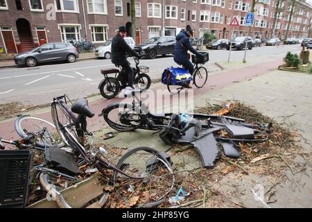 Amsterdam, Paesi Bassi. 19th Feb 2022. I ciclisti passano accanto alle biciclette naufragate dove un albero è caduto uccidendo una persona ieri pomeriggio durante i venti forti della tempesta Eunice il 19 febbraio 2022 ad Amsterdam, Paesi Bassi. Tempesta Eunice passò attraverso i Paesi Bassi con venti che raggiungevano 130 km all'ora uccidendo quattro persone erano cadendo alberi. (Foto di Paulo Amorim/Sipa USA) Credit: Sipa USA/Alamy Live News Foto Stock