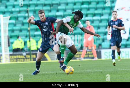 Easter Road Stadium, Edinburgh.Scotland UK.19th Feb 22 Hibernian vs Ross County Cinch Premiership Match. Il difensore belga di Hibs, Rocky Bushiri, si lancia con l'attaccante della contea di Ross, Jordan White,(26) Credit: eric mccowat/Alamy Live News Foto Stock