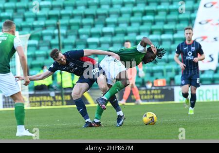 Easter Road Stadium, Edinburgh.Scotland UK.19th Feb 22 Hibernian vs Ross County Cinch Premiership Match. Il difensore belga di Hibs, Rocky Bushiri, si lancia con l'attaccante della contea di Ross, Jordan White,(26) Credit: eric mccowat/Alamy Live News Foto Stock