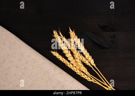 Grano naturale su tessuto artigianale su sfondo nero scuro con spazio copia Foto Stock