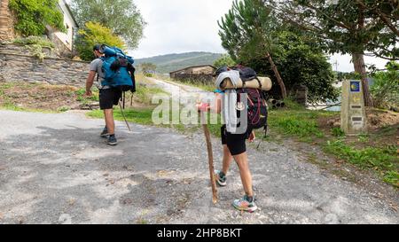 Lugo, Spagna - Agosto 12 2021: Camino de Santiago, Via di San Giacomo, alla Cattedrale di Compostela, Galizia, Spagna. Pellegrini con backpackers a piedi alon Foto Stock