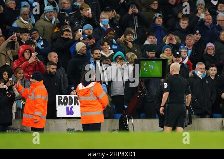 L'arbitro Anthony Taylor guarda una TV sul lato del campo, dopo che il VAR gli ha consigliato di controllare una decisione che gli ha portato a premiare Manchester City un calcio di punizione durante la partita della Premier League all'Etihad Stadium di Manchester. Data foto: Sabato 19 febbraio 2022. Foto Stock