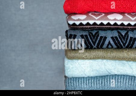 Una pila di maglioni, jumper. Un mazzo di coloni colorati di lana. Strati, la consistenza dei vestiti Foto Stock