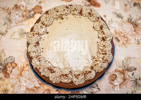 Dessert al cioccolato al caramello intero torta fatta in casa sopra piano vista dall'alto di glassa marrone e decorazione delle rose su vintage autunno autunno tovaglia clos Foto Stock