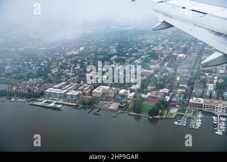 Vista aerea dell'aeroplano attraverso la finestra di Alexandria nel Nord della Virginia in una giornata nuvolosa vicino al fiume Washington DC Potomac che scende al Reagan National Foto Stock