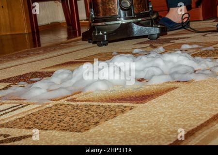 Il processo di pulizia della moquette con un aspirapolvere e un filtro dell' acqua. Una mano donna inserisce un tubo dell'aspirapolvere nell'uscita  dell'aria Foto stock - Alamy