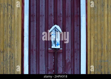 Termometro su un magazzino di legno in una giornata di congelamento in terra finlandese, Finlandia, in inverno Foto Stock