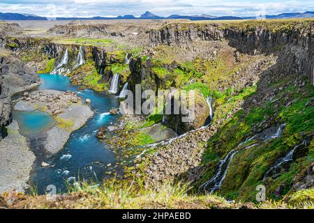 Vista estiva delle cascate nel canyon di Sigoldugljufur e del fiume blu nelle Highlands dell'Islanda. Foto Stock