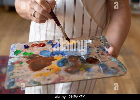 Primo piano su artista femminile ritagliato tenendo tavolozza in mani. Foto Stock