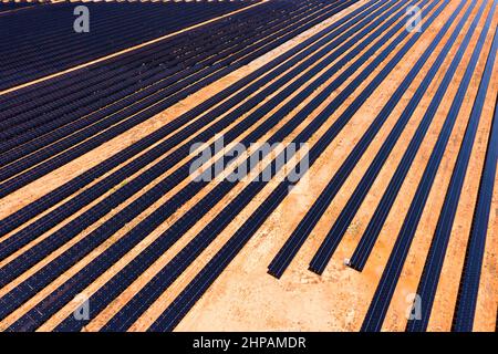 Rottura della centrale elettrica in collina di pannelli solari su una fattoria di generazione di elettricità - vista dall'alto in basso aerea. Foto Stock