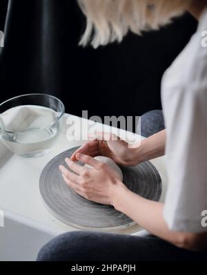 La ragazza lavora alla ruota del vasaio Foto Stock