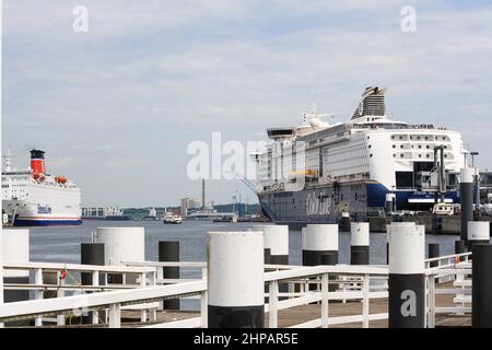 Vista di una grande nave da crociera per passeggeri ancorata al terminal dei traghetti nel Porto di Kiel con nuvole su sfondo blu del cielo estivo. Nessuna gente. Foto Stock