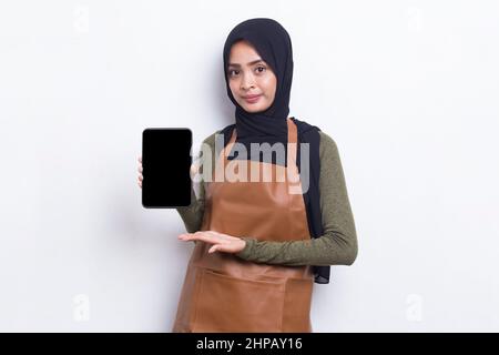 La cameriera asiatica del barista musulmano dimostra il telefono cellulare su sfondo bianco Foto Stock