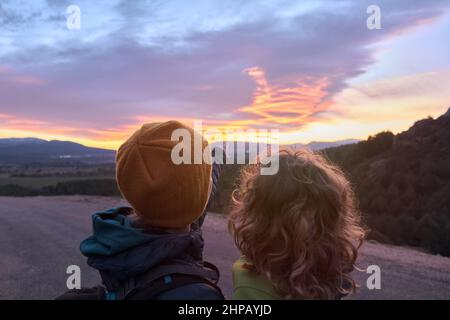 Madre con figlio che si gode il tramonto sulla natura Foto Stock