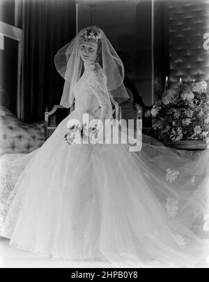 Un modello di moda britannico, da una fotografia professionale del 1950s. Modellare un abito da sposa. Foto Stock