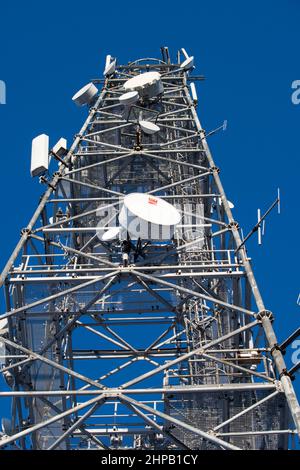 torre per telecomunicazioni con antenne su un cielo blu Foto Stock