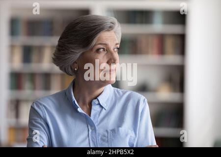 Felice sognante pensione vecchia donna guardando in lontananza. Foto Stock