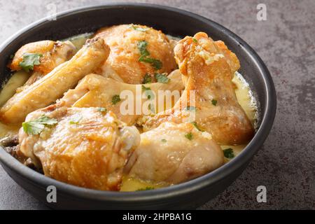 Shkmeruli è un piatto tradizionale caucasico georgiano di pollo in spicup salsa all'aglio nella pentola sul tavolo. Orizzontale Foto Stock