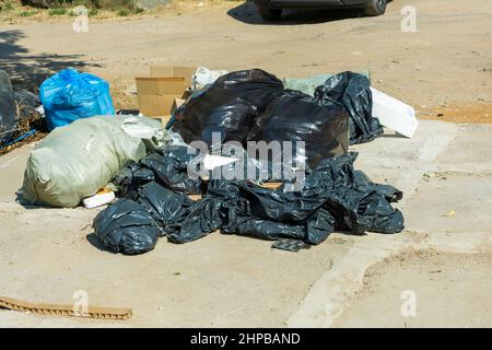 Sacchetti di plastica con rifiuti sono giacenti sul sito, detriti di costruzione in sacchetti, ecologia, protezione ambientale, pile di sacchetti chiusi con rifiuti Foto Stock