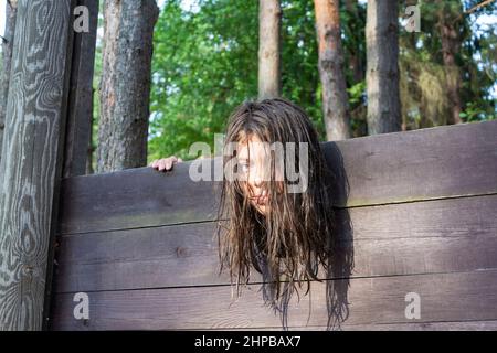 la testa di una ragazza con lunghi capelli disheveled bloccato in una ghigliottina, una scena di un'esecuzione medievale, una frase. Foto Stock