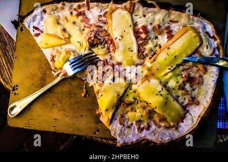 Flammkuchen non dovrebbe mancare in nessun viaggio in Alsazia. È disponibile in molte varianti. Qui la versione con abbondante formaggio Munster Foto Stock