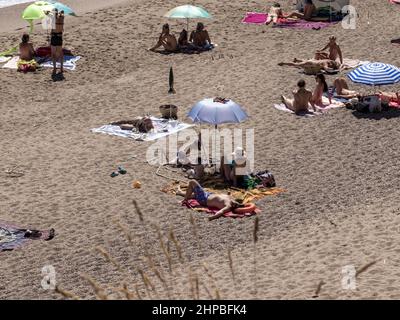 Gruppo di turisti che si godono la spiaggia in una soleggiata giornata estiva in Costa Brava, Spagna Foto Stock