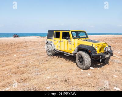 Yellow Jeep Wrangler sulla spiaggia nella penisola di Akamas Foto Stock