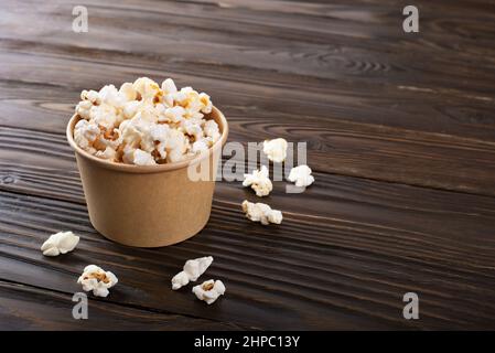 Spuntino a base di mais in un secchio di carta sul tavolo da cucina Foto Stock