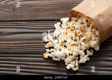 Spuntino a base di mais in sacchetto di carta sul primo piano del tavolo di legno Foto Stock