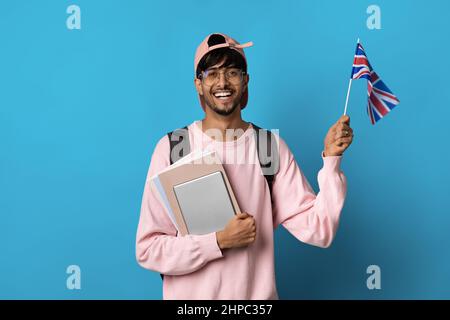 Felice ragazzo arabo studente mostrando bandiera del Regno Unito Foto Stock