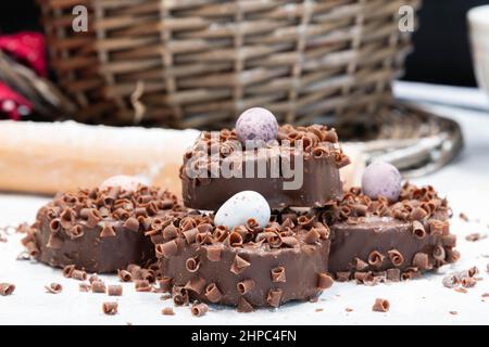 Quattro piccole torte pasquali ricoperte di cioccolato. Cottura di Pasqua in preparazione per le vacanze di Pasqua in Scozia. Foto Stock