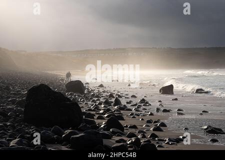 Fascio di luce solare invernale a Portballintree Beach, Ballycastle, Irlanda del Nord Foto Stock