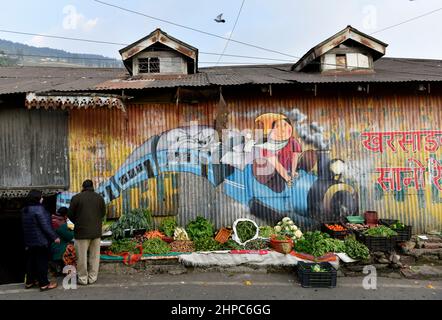 Kurseong, Bengala Occidentale, India. 20th Feb 2022. Un uccello volare sopra un mercato vegetale dove un dipinto murale può essere visto in Kurseong, distretto di Darjeeling, Bengala occidentale, India, 20 febbraio, 2022. (Credit Image: © Infranil Aditya/ZUMA Press Wire) Foto Stock
