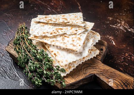 Felice concetto di Pasqua, matzah su un asse di legno. Sfondo scuro. Vista dall'alto Foto Stock