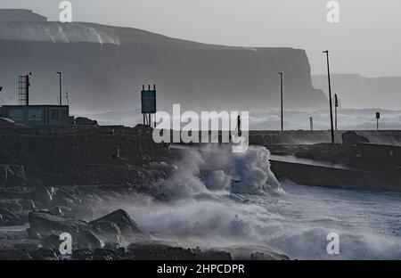 Una persona guarda le onde a Doolin nella contea di Clare sulla costa occidentale dell'Irlanda. Data foto: Domenica 20 febbraio 2022. Foto Stock