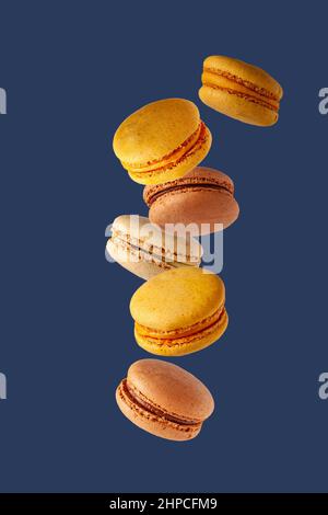 macaroon colorati che volano su sfondo blu Foto Stock