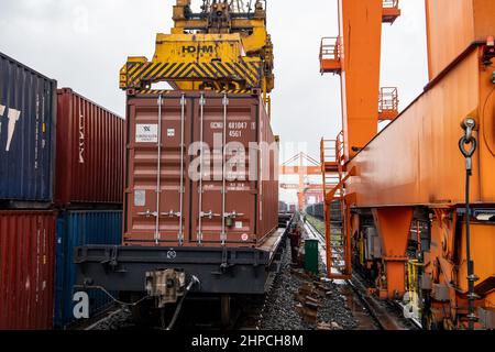 Chongqing, Cina. 19th Feb 2022. Un container viene caricato su un treno merci al Porto di Guoyuan a Chongqing, Cina sudoccidentale, 19 febbraio 2022. Un treno merci Yuxin'ou (Chongqing-Xinjiang-Europe) Cina-Europa che trasporta più di 1.100 tonnellate di alcool polivinilico (PVA) e altri prodotti chimici fini ha lasciato il porto di Guoyuan a Chongqing per Duisburg di Germania il 20 febbraio. Credit: Tang Yi/Xinhua/Alamy Live News Foto Stock