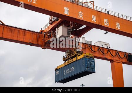 Chongqing, Cina. 19th Feb 2022. Un ponte gru opera al Porto di Guoyuan a Chongqing, Cina sudoccidentale, 19 febbraio 2022. Un treno merci Yuxin'ou (Chongqing-Xinjiang-Europe) Cina-Europa che trasporta più di 1.100 tonnellate di alcool polivinilico (PVA) e altri prodotti chimici fini ha lasciato il porto di Guoyuan a Chongqing per Duisburg di Germania il 20 febbraio. Credit: Tang Yi/Xinhua/Alamy Live News Foto Stock