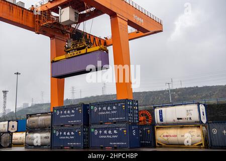 Chongqing, Cina. 19th Feb 2022. Un ponte gru opera al Porto di Guoyuan a Chongqing, Cina sudoccidentale, 19 febbraio 2022. Un treno merci Yuxin'ou (Chongqing-Xinjiang-Europe) Cina-Europa che trasporta più di 1.100 tonnellate di alcool polivinilico (PVA) e altri prodotti chimici fini ha lasciato il porto di Guoyuan a Chongqing per Duisburg di Germania il 20 febbraio. Credit: Tang Yi/Xinhua/Alamy Live News Foto Stock