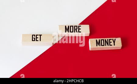 Blocchi di legno con testo Get Money Cash su sfondo rosso e bianco Foto Stock