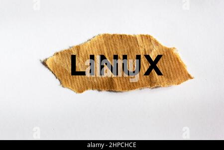 Linux. Testo su carta marrone strappata isolato su sfondo bianco. Foto Stock