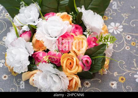 Anelli di nozze in un bouquet di fiori gialli, rosa e bianchi Foto Stock