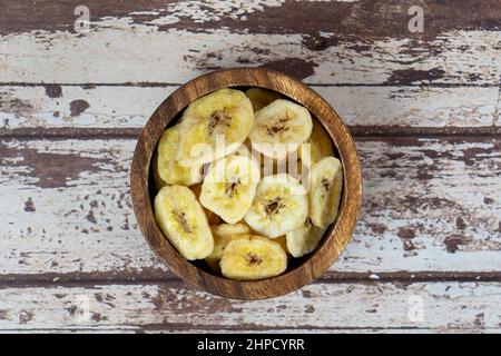 Trucioli di banana essiccati in un piatto di legno. Foto Stock