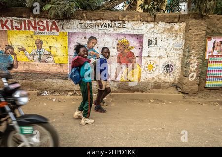 Gli allievi camminano a casa dalla scuola passando per le strade nelle baraccopoli di Kibera. All'interno di Kibera Slum, la famigerata casa dove la vita sembra sempre difficile e la cha Foto Stock