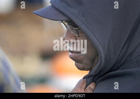 Black African American Senior Face Farmer allo swap Meet in Amish Country of Walnut Creek Ohio, vendendo ciò che ha per reddito in autunno con felpa con cappuccio Foto Stock