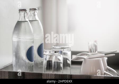 due bottiglie di acqua minerale in camera, nonché bicchieri puliti su un vassoio Foto Stock