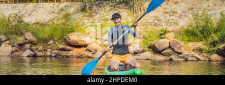 L'uomo gioioso sta addestrando la scheda SUP nel fiume in una mattinata di sole. Stand up paddle boarding - fantastico banner attivo per attività ricreative all'aperto, FORMATO LUNGO Foto Stock