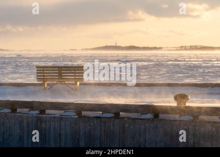 In inverno al tramonto, nel Bas-Saint-Laurent, in mezzo alla neve e ghiaccio il molo del porto di Kamouraska (Quebec, Canada) Foto Stock