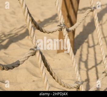 Rete di arrampicata su corda al parco giochi. Parco avventura corda. Moderno parco giochi per bambini realizzato con materiali naturali. Foto Stock